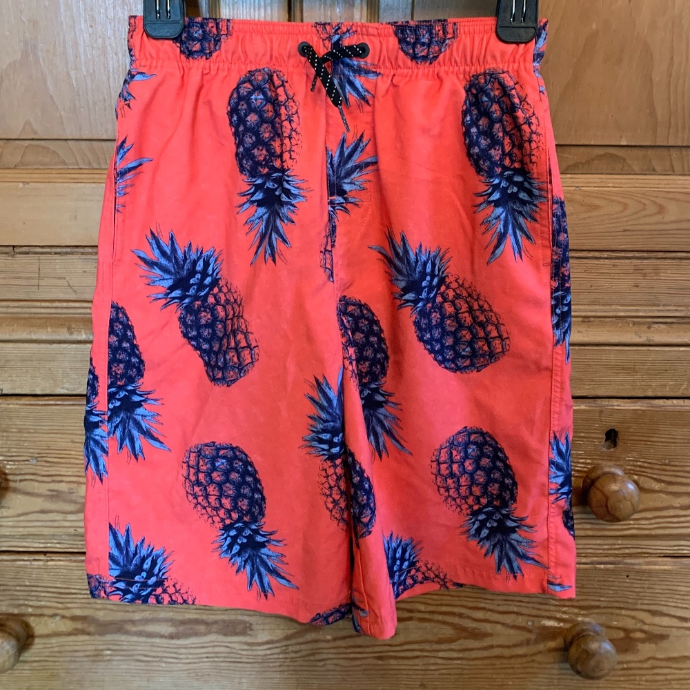 Coral swim trunks with pineapples.